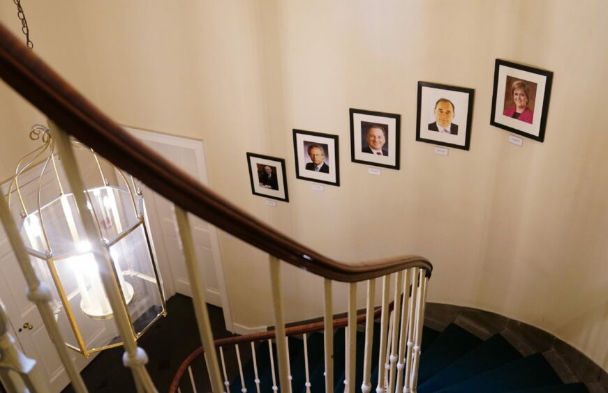 staircase at Bute House showing photographs of all of the First Ministers of Scotland