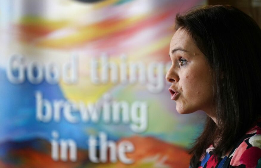 Kate Forbes in front of a sign which reads 'Good things brewing'