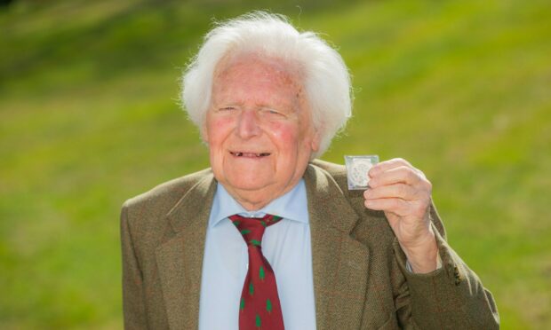 George Stewart of Scone who has died aged 103. He is pictured in 2021 with a letter and a set of coins he received as part of the annual Royal Maundy Service .