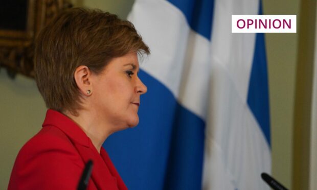 Nicola Sturgeon in front of a saltire flag.