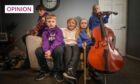 group of youngsters with musical instruments seated around their grandmother.
