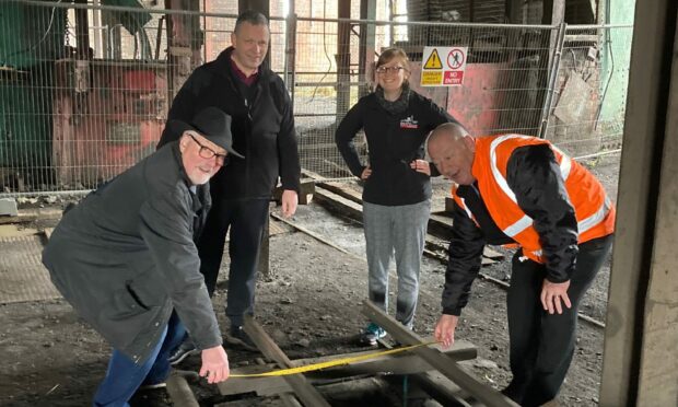 Iain Chalmers (front left) with Watty Watson, committee member of Save the Cage and ex colliery official (front right) along with Ian Lang, Lochore Meadows Country Park manager, and Nicola Moss, the curator at the National Mining Museum of Scotland. They are pictured at the National Mining Museum of Scotland to identify those pieces of mining equipment they would like displayed around the Mary Colliery head frame at Lochore. Image: Iain Chalmers