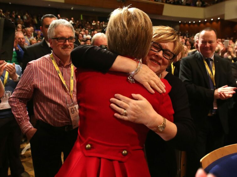 Nicola Sturgeon is embraced by her mother in a crowd of SNP supporters at the party conference in Perth Concert Hall.