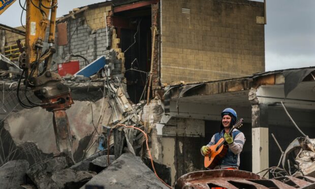 A demolition worker finds a guitar among the debris as demolition of Kirkcaldy's Postings Shopping Centre begins. Image: Mhairi Edwards/DC Thomson