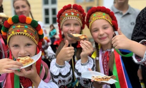 Ukrainian girls from a well known traditional performance group who used to tour Europe, enjoying pizza served by Siobhan's Trust. Ukraine. Image: Jennifer de Tapia