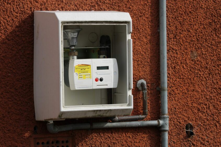 Pre-payment meter on wall outside a house.