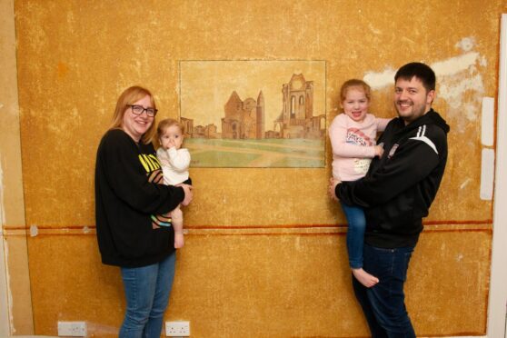 Kayleigh Ross and partner Liam Smith with their children Ava, 5, and one-year-old Macy beside the Abbey mural. Image: Paul Reid