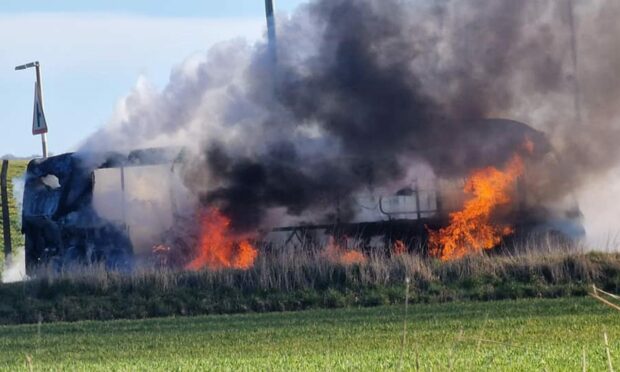 Flames rip through the bus on Battenberg Road near the Royal Marines base at Condor. Image: Ross Pert.