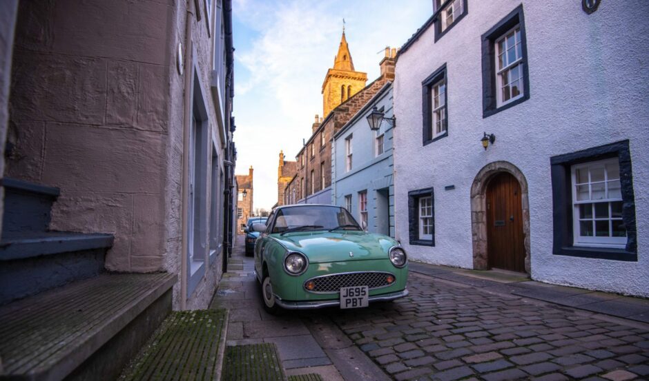 Classic car on charming cobbled street in St Andrews.