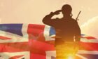 Soldier saluting before flag.