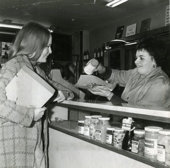 A woman being served at Baluniefield Road Chip Shop. 