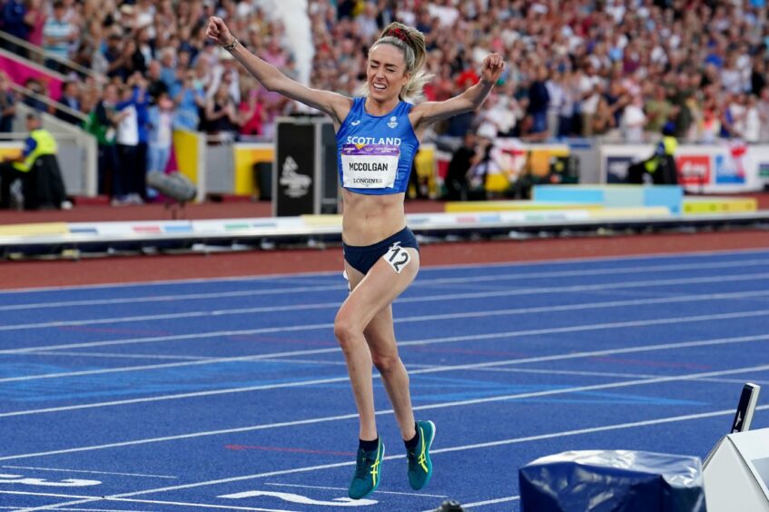 Eilish McColgan holds arms aloft after winning silver at Birmingham Commonwealth Games.