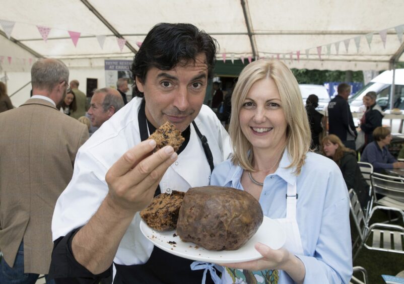 Michelle Maddox with chef Jean-Christophe Novelli holding a slice of dumpling.