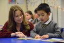 A teacher helps a pupil as he makes the P1 transition from nursery