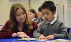 A teacher helps a pupil as he makes the P1 transition from nursery