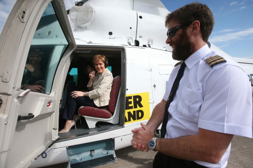 Nicola Sturgeon seated inside a helicopter as it prepares to take off.