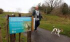 Ian Ford of Friends of Riverside Nature Park alongside a sign at Riverside Nature Park. Image: DC Thomson.