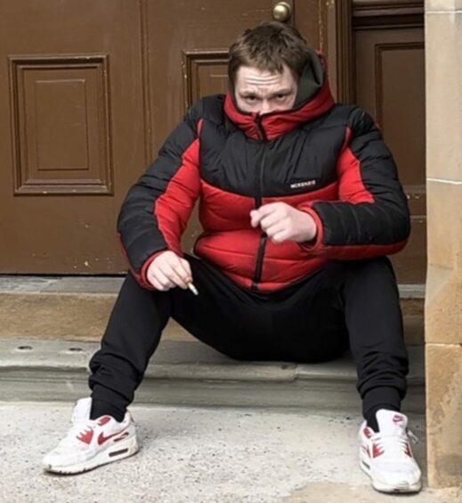 Arbroath knicker thief Graham Orrock tries to cover his face outside court.