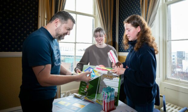 (Left to right) Ukrainian Sermiy Onushcmak gets dental health advice from Jessica Mannion and Ruby Soldan, Queens Hotel, Nethergate, Dundee. Image: Kim Cessford / DC Thomson