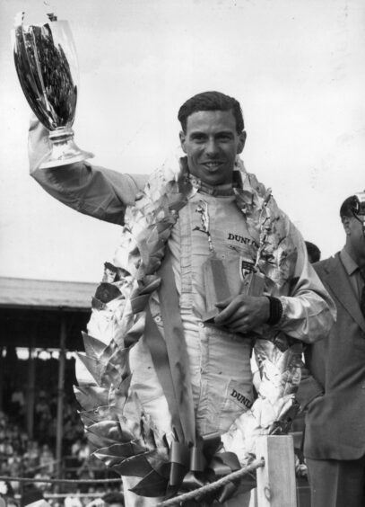 Jim Clark with his trophies and garland after winning the British Grand Prix at Silverstone in 1963.