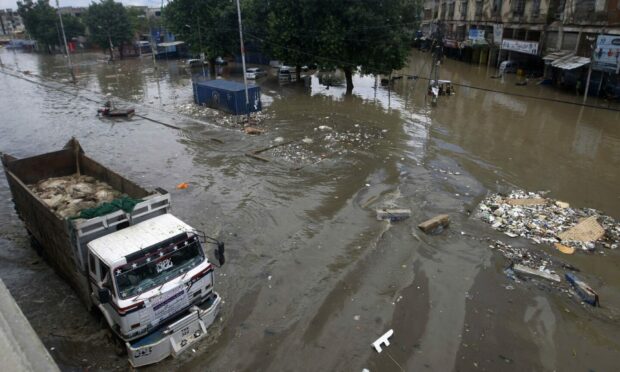 A truck drives through a flooded road after a heavy rainfall in Karachi, Pakistan, last year. Image: AP/Fareed Khan)