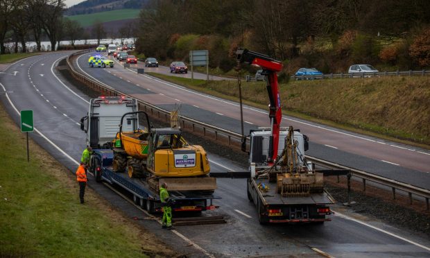 The digger being towed away.