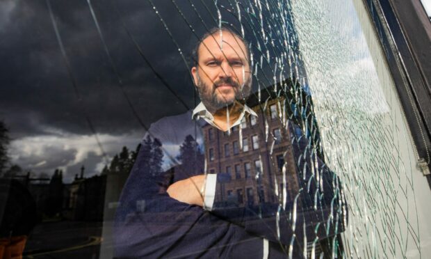 Vito Crolla and the smashed window at Roma Ristorante in Perth. Image: Steve MacDougall/DC Thomson