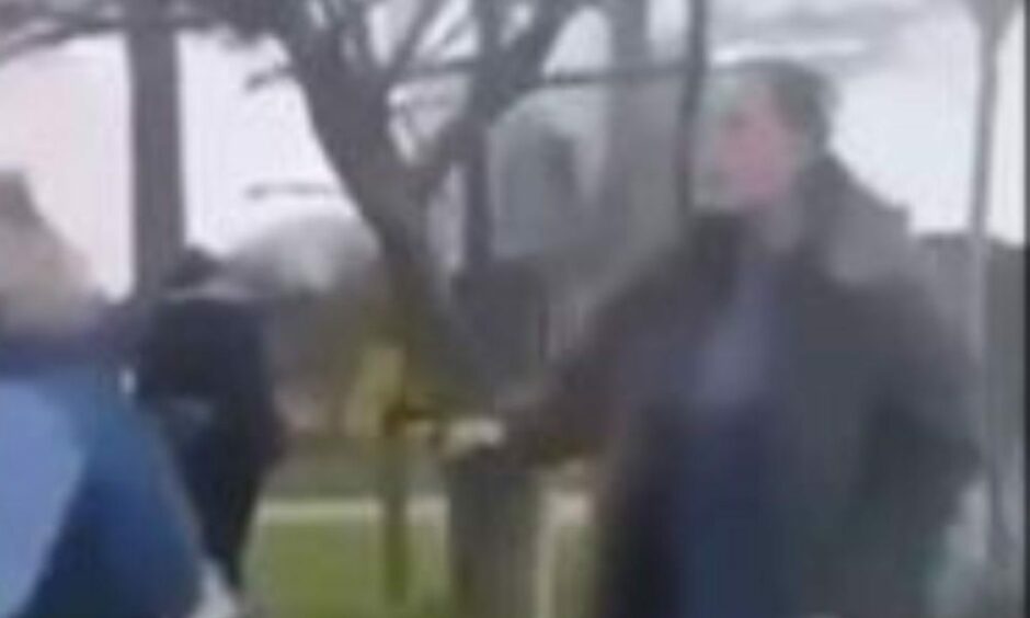 blurry still from a video showing a woman with her mouth open