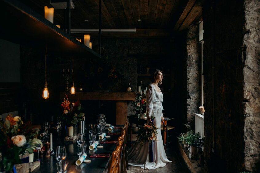 Bride at wedding venue The Bothy Glasgow, surrounded by candles and flowers.