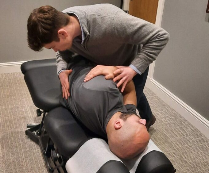 Chiropractor performing a back adjustment at clinic in Perth Scotland