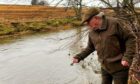 Eden Angling Association president Bill Wardlaw throws whisky in the river during a traditional opening ceremony. Image: Eden Angling Association.