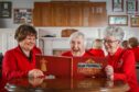 Carnoustie Ladies members Mary Summers, Jean Reyner and current club captain Jean McNicoll leaf through the 150th anniversary book. Image: Mhairi Edwards/DC Thomson
