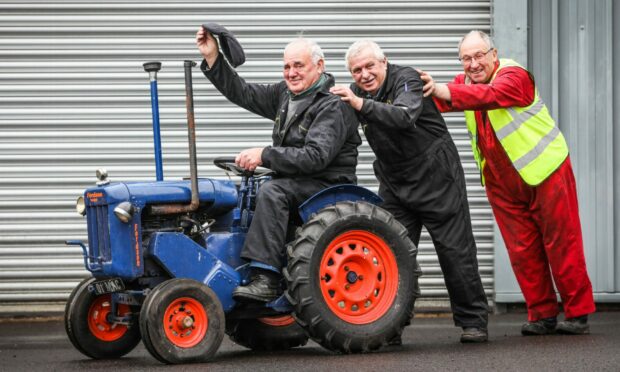 SVVC trustees Eck Steele, Andy Penman and Jock Findlay have a turn on the miniature hand-built Fordson tractor. Image: Mhairi Edwards/DC Thomson