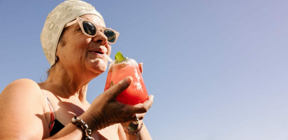 Older woman drinking a cocktail.