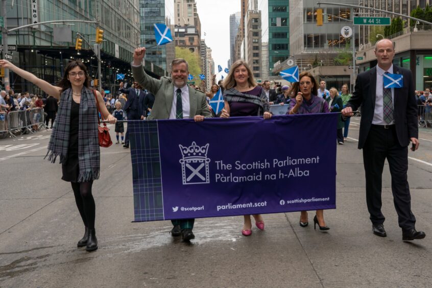 Angus Robertson as part of a group walking behind a Scottish Parliament banner at Tartan Day in New York.