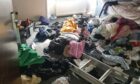 Clothes left strewn across a room of the Dura Street flat. Image: Supplied