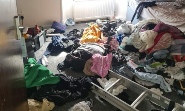Clothes left strewn across a room of the Dura Street flat. Image: Supplied
