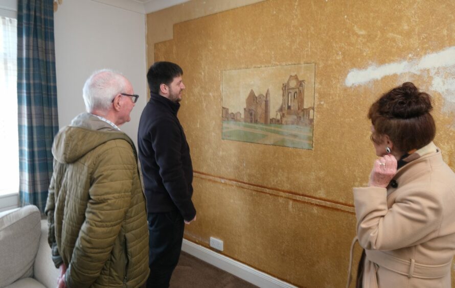 Nancy and John admire the Abbey artwork with current homeowner Liam.