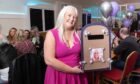 Julie Mitchell with a box containing messages from friends and family at the party celebrating her life. Image: Paul Reid.