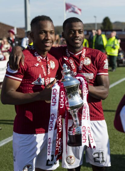 Kelty Hearts won the League Two title in 2022. Two players hold the trophy on the pitch. Image: SNS