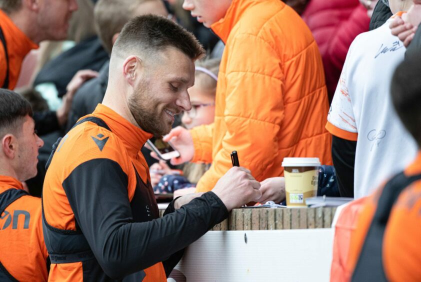 Dundee United captain Ryan Edwards signs autographs for supporters at Tannadice.