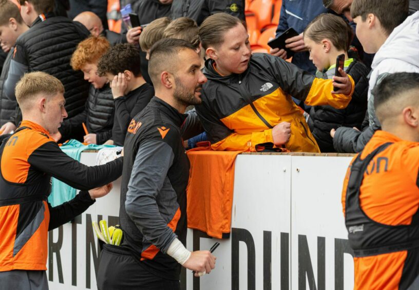 Dundee United goalkeeper Mark Birighitti poses for selfie with fan.