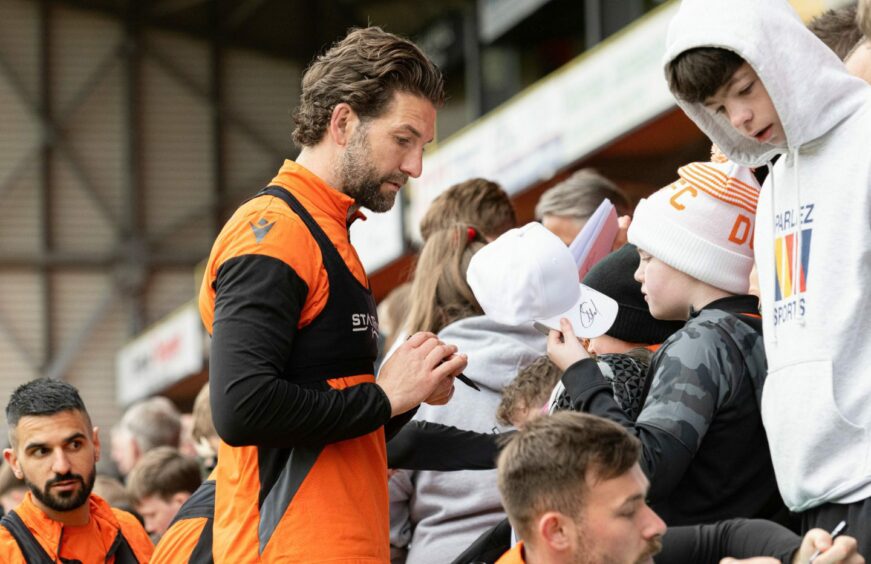 Charlie Mulgrew signs hat for youngster.