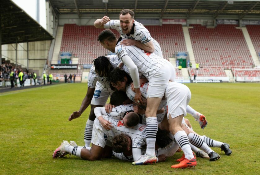 Chris Hamilton joins the pile-on after Lewis McCann's winning goal