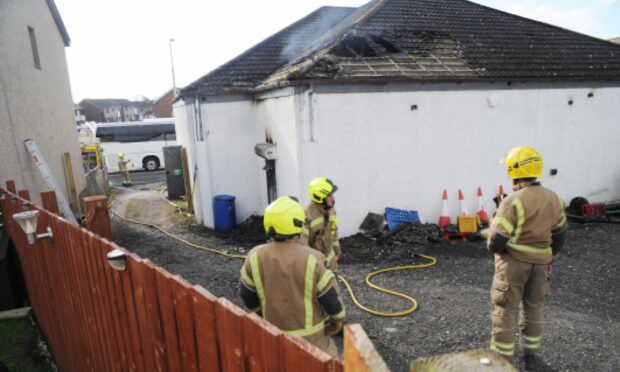 Flames have torn through the roof of the shop in Crosshill. Image: David Wardle