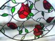 stained glass window featuring red roses, green leaves and black lead