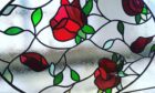 stained glass window featuring red roses, green leaves and black lead