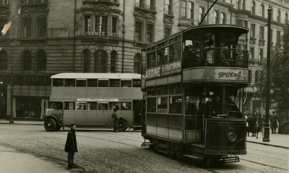 Old and New: A Broughty Ferry tram passes a bus on Commercial Street in 1931. Image: DC Thomson.