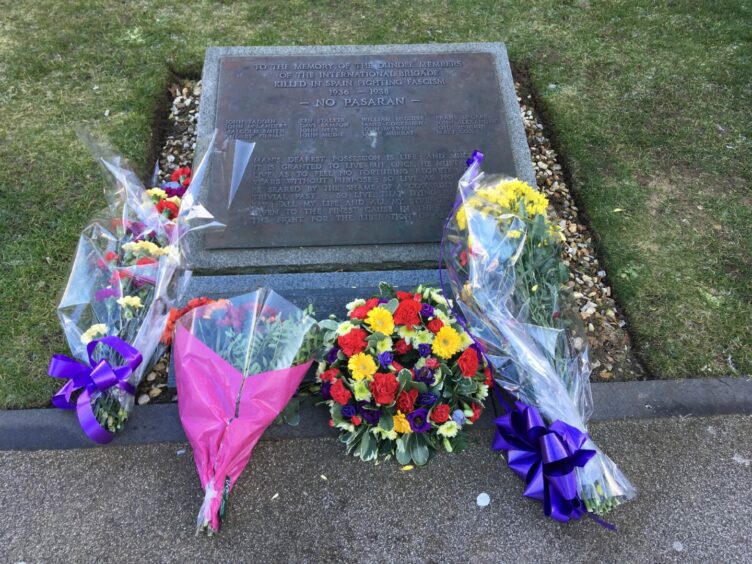 Flowers laid by the Spanish Civil War plaque on the grounds of the McManus Galleries in Dundee.