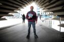 Mark Richardson with copies of his new book, outside the V&A, Riverside Esplanade, Dundee. Image: Kim Cessford / DC Thomson